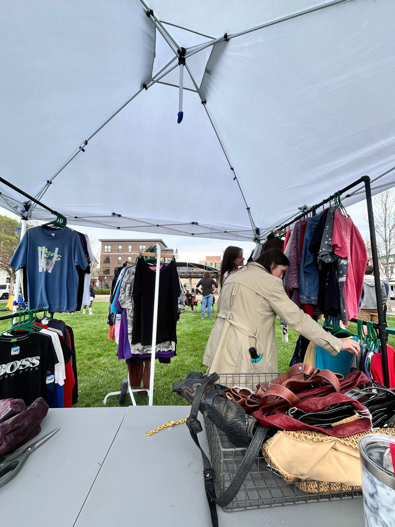 The College Artisans vintage clothing tent at an outdoor campus event