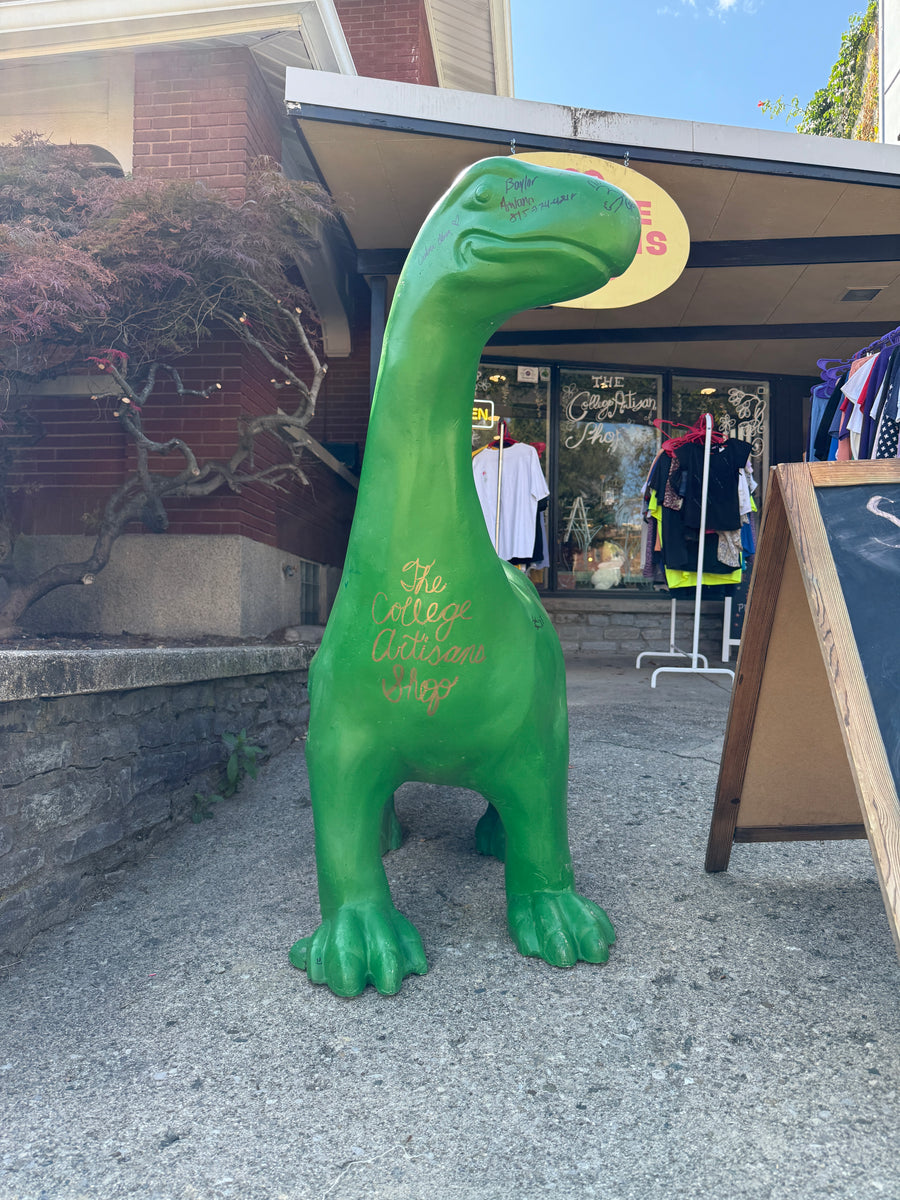 The College Artisans Shop dinosaur mascot outside the Uptown Oxford store